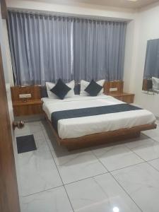 1 dormitorio con 1 cama grande con almohadas azules en hotel gateway inn en Ahmedabad