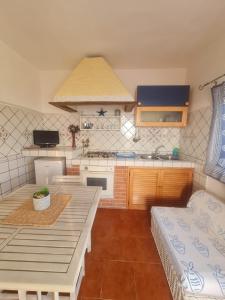 a kitchen with a table and a counter top at Le Case dei Pescatori - Casetta Faraglioni in Ponza