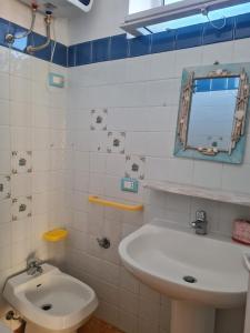 a white bathroom with a sink and a toilet at Le Case dei Pescatori - Casetta Faraglioni in Ponza