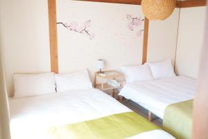 two beds in a room with white sheets at OK house2 住吉大社Available for up to 8 people in Osaka