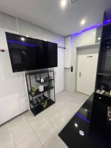 a living room with a flat screen tv on a wall at Room & Jacuzzi - Stade de France in Saint-Denis