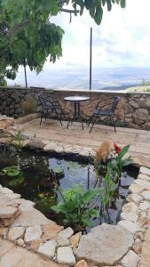 a patio with a table and chairs and a pond at Relaxed garden apartment with Galilee sea view 1 in Safed