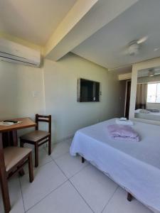 薩誇雷馬的住宿－Hotel Aconchego Da Vila，一间卧室配有一张床、一张桌子和一面镜子