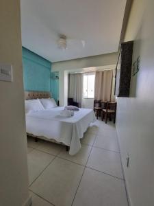 een slaapkamer met een bed en een tafel. bij Hotel Aconchego Da Vila in Saquarema