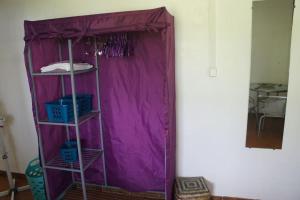 a purple shelf with three blue baskets in a room at Bas de villa, hauteurs du Robert in Le Robert +9 photos