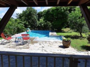 a view of a pool with two chairs and a table at Bas de villa, hauteurs du Robert in Le Robert
