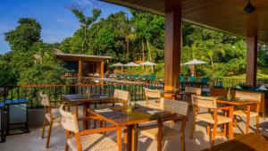 ein Restaurant mit Holztischen und -stühlen auf einer Terrasse in der Unterkunft Sanglung Villas & Suites in Kubutambahan