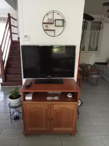 TV de pantalla plana en un soporte de madera en la sala de estar. en Bienvenue, en Marly