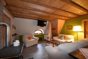 a living room with white furniture and a tv at Wohlfühl-Villa in Themar in Themar