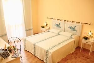 een slaapkamer met een bed, 2 tafels en een raam bij Hotel with swimming pool in La Maddalena, breakfast included in La Maddalena