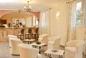 une salle d'attente avec des chaises blanches et un bar dans l'établissement Hotel with swimming pool in La Maddalena, breakfast included, à La Maddalena