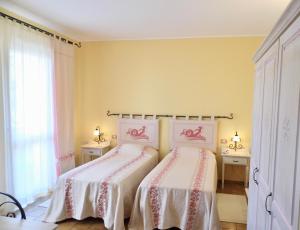 2 camas en un dormitorio con paredes amarillas en Hotel with swimming pool in La Maddalena, breakfast included, en La Maddalena
