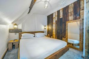 1 dormitorio con 1 cama grande y pared de madera en Chester Rose on the Chester Rows, en Chester
