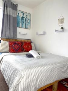 um quarto com uma cama grande e almofadas vermelhas em Crescent Apartment - Modern 1 Bedroom First Floor em Goodmayes