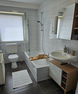 a bathroom with a sink and a tub and a toilet at Rheinhessenglück 