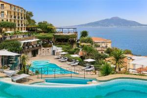 een uitzicht op een resort met een zwembad en de oceaan bij Grand Hotel Capodimonte in Sorrento