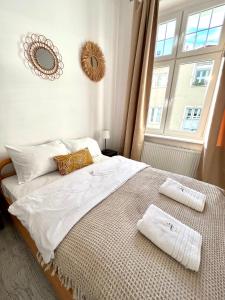 una camera da letto con un grande letto con asciugamani di Agapella Apartamenty - Apartament Goyki 300 m from the beach a Sopot