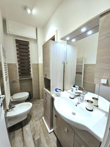 uma casa de banho com um lavatório, um WC e um espelho. em Casa Mavira House em Rimini