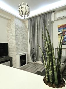 uma sala de estar com lareira e um vaso de plantas em Casa Mavira House em Rimini