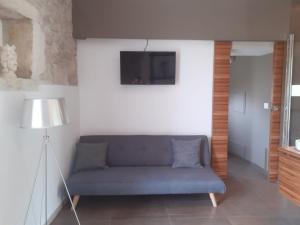 uma sala de estar com um sofá azul e uma televisão em Itria Palace em Ragusa