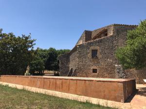 RupiáにあるMas Catalàのレンガ壁と木々のある古い建物
