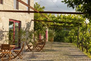 a patio with chairs and tables and vines at Peso Village in Amarante