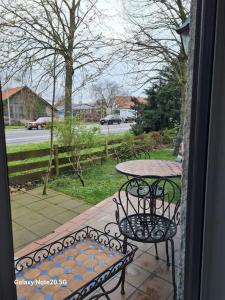 a table and chairs on a porch with a view of a street at Lilias Ruheoase in Pfungstadt +24 photos