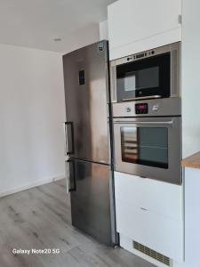 a kitchen with a stainless steel refrigerator and a microwave at Lilias Ruheoase in Pfungstadt