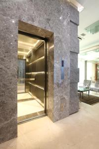 an elevator in a lobby with a stone wall at Regency Hotel Malabar Hill in Mumbai