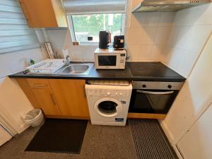 a small kitchen with a sink and a washing machine at Studio London Hackney near Homerton Hospital in London