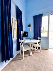 エルミオニにあるBlue Loft by Gcollectiongrの青い部屋(白いテーブルと椅子付)