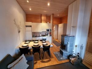a kitchen with a table with chairs and a stove at Kuukkeli Apartments Suite in Saariselka