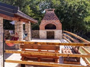 a brick oven with a wooden bench in front of it at Agroturizam Villa Antonija in Neum