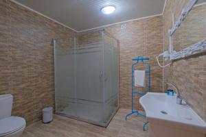 a bathroom with a shower and a toilet and a sink at Adrasan Hotel in Kumluca