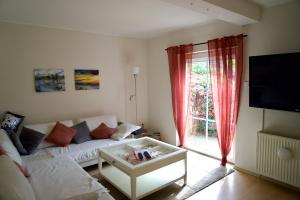 sala de estar con sofá blanco y TV en Gemütliches Haus mit großem traumhaften Garten en Bremen