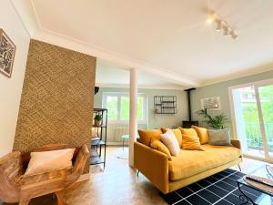 sala de estar con sofá amarillo en una habitación en Bel appartement 100 m2 / Parking / Paisible, en Rodez