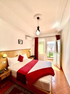 a bedroom with a large bed and a window at Sary's Hotel in M'diq