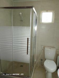 uma casa de banho com um chuveiro, um WC e uma janela. em Milky Way Bedouin Camp em Wadi Rum