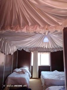 a canopy over two beds in a bedroom at Milky Way Bedouin Camp in Wadi Rum