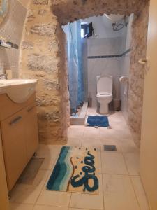 a bathroom with a toilet and a rug on the floor at Stonehouse in Mani Penisula in Koíta