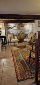 a living room with chairs and a rug at La petite Provence in Bormes-les-Mimosas