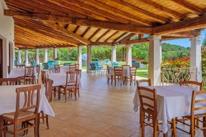 a restaurant with white tables and chairs on a patio at Tenuta Lu Baroni in Porto Ottiolu