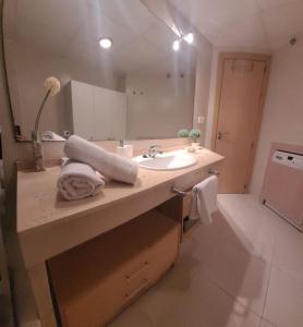 La salle de bains est pourvue d'un lavabo et d'un grand miroir. dans l'établissement Apto Laguna Beach Vera Playa, à Vera