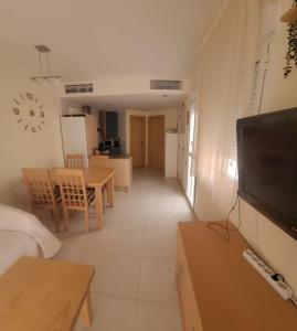 un salon avec une télévision et une salle à manger dans l'établissement Apto Laguna Beach Vera Playa, à Vera