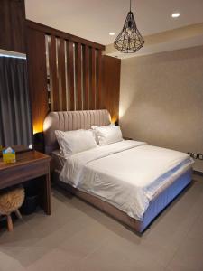 sypialnia z łóżkiem i drewnianym zagłówkiem w obiekcie Luxury Apartments - Damac Tower Amman w mieście Amman