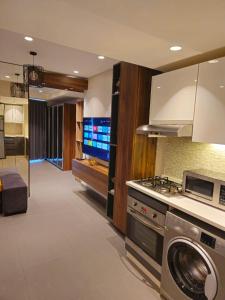 a kitchen with a stove and a washing machine at Luxury Apartments - Damac Tower Amman in Amman