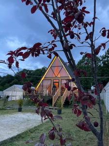 una casa con un árbol delante de ella en A Frame Lankaran, en Lankaran