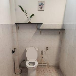 uma casa de banho com um WC com uma prateleira na parede em บ้านพักในสวนK&N1 