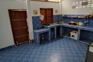 uma cozinha com piso em azulejo azul e balcões em บ้านพักในสวนK&N1 
