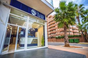 ein Gebäude mit einer Palme davor in der Unterkunft Casa Coral Ivan Luxury Homes 9ªPlta Sur 1ªLinea in Oropesa del Mar